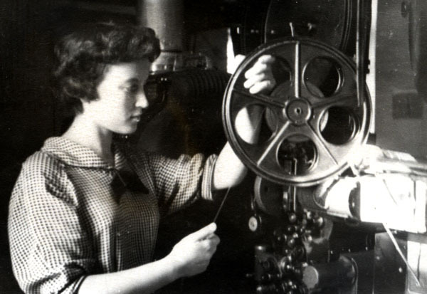 Девушка-киномеханик заряжает кинопроекционный аппарат, 1960-е-1980-е гг.